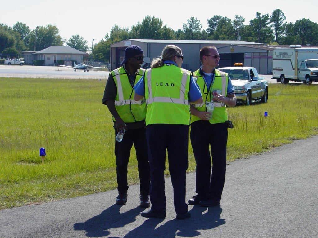 Three officers standing on pavement, waiting for instruction.